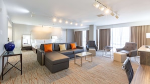 Une chambre d’hôtel avec un grand lit, un canapé, une table basse et un bureau.