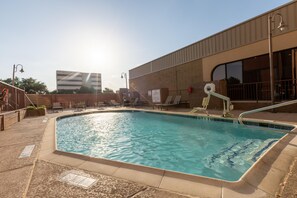 Une piscine avec un poste de surveillance pour les sauveteurs et des chaises longues.