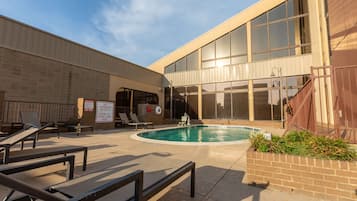 Una piscina al aire libre, sillones reclinables de piscina