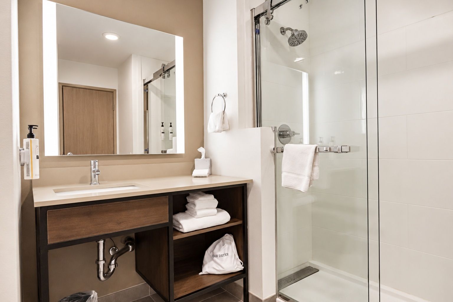A modern bathroom with a glass shower enclosure, a vanity with a mirror, and a towel rack.
