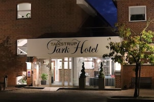 Un edificio de ladrillo con un cartel que indica el Hotel Taastrup Park.