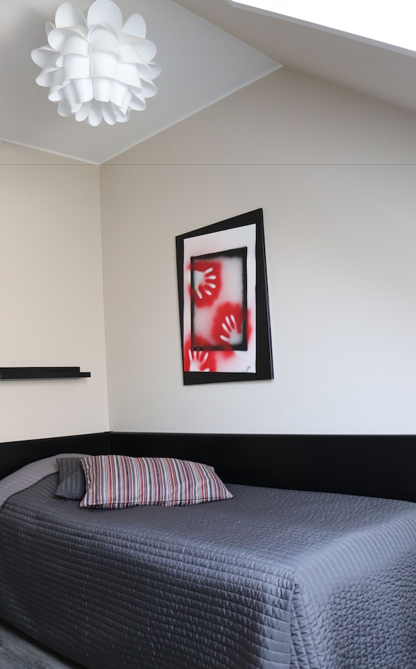 A bedroom with a bed, a pillow, a framed artwork, and a ceiling light fixture. - Taastrup Park Hotel (Taastrup)