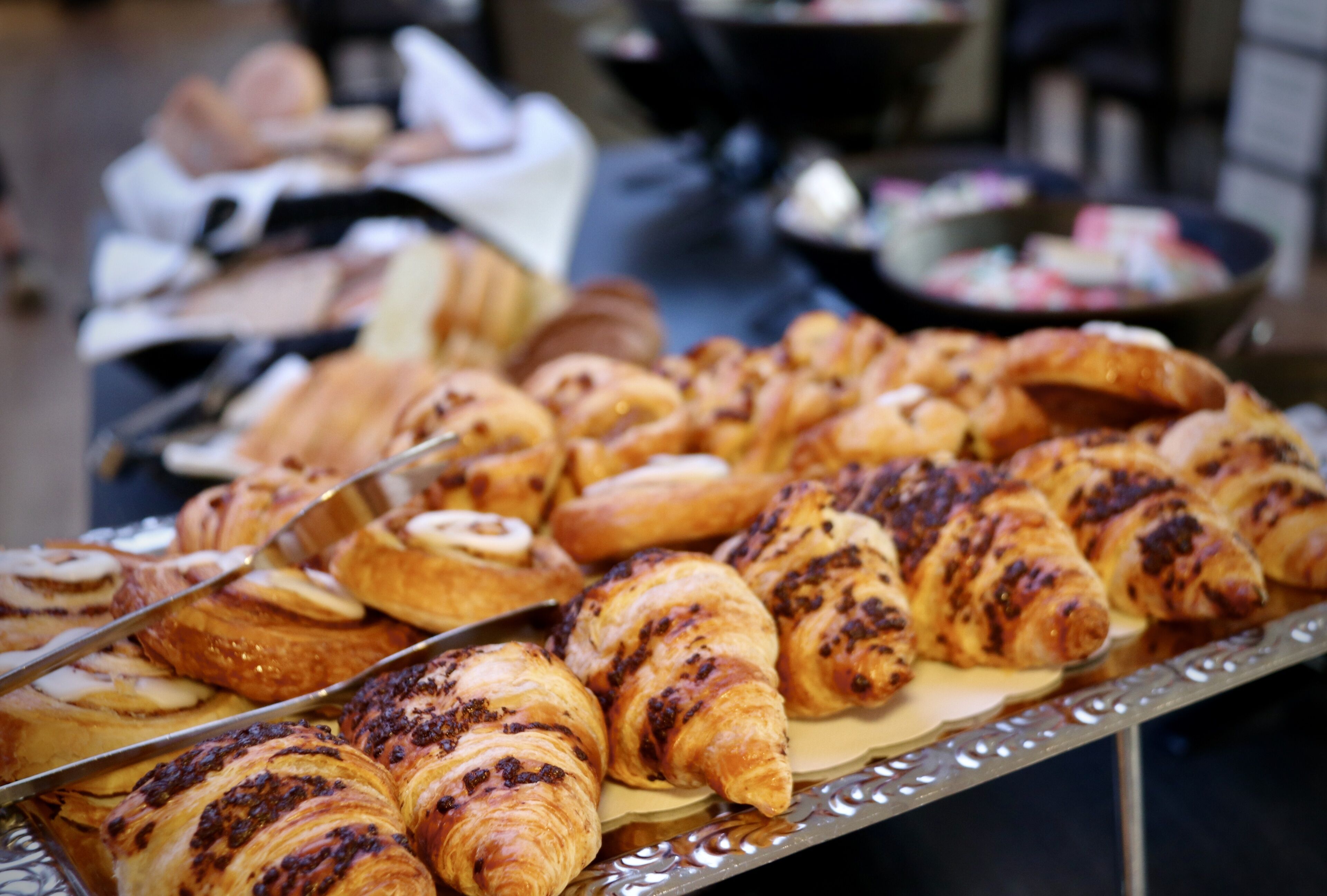 A variety of pastries on a tray, including croissants and other baked goods.