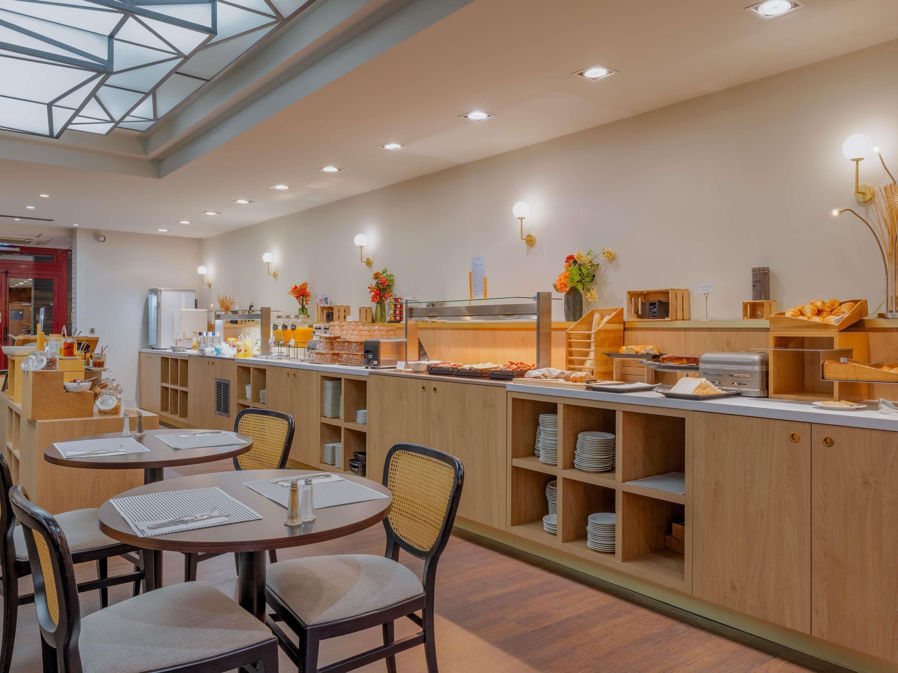 A modern breakfast area with a long counter, multiple seating options, and a variety of breakfast items.