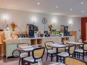 A cafe with tables and chairs, a coffee machine, and a clock on the wall. - Mercure Lyon Est Villefontaine (Vaulx-Milieu)
