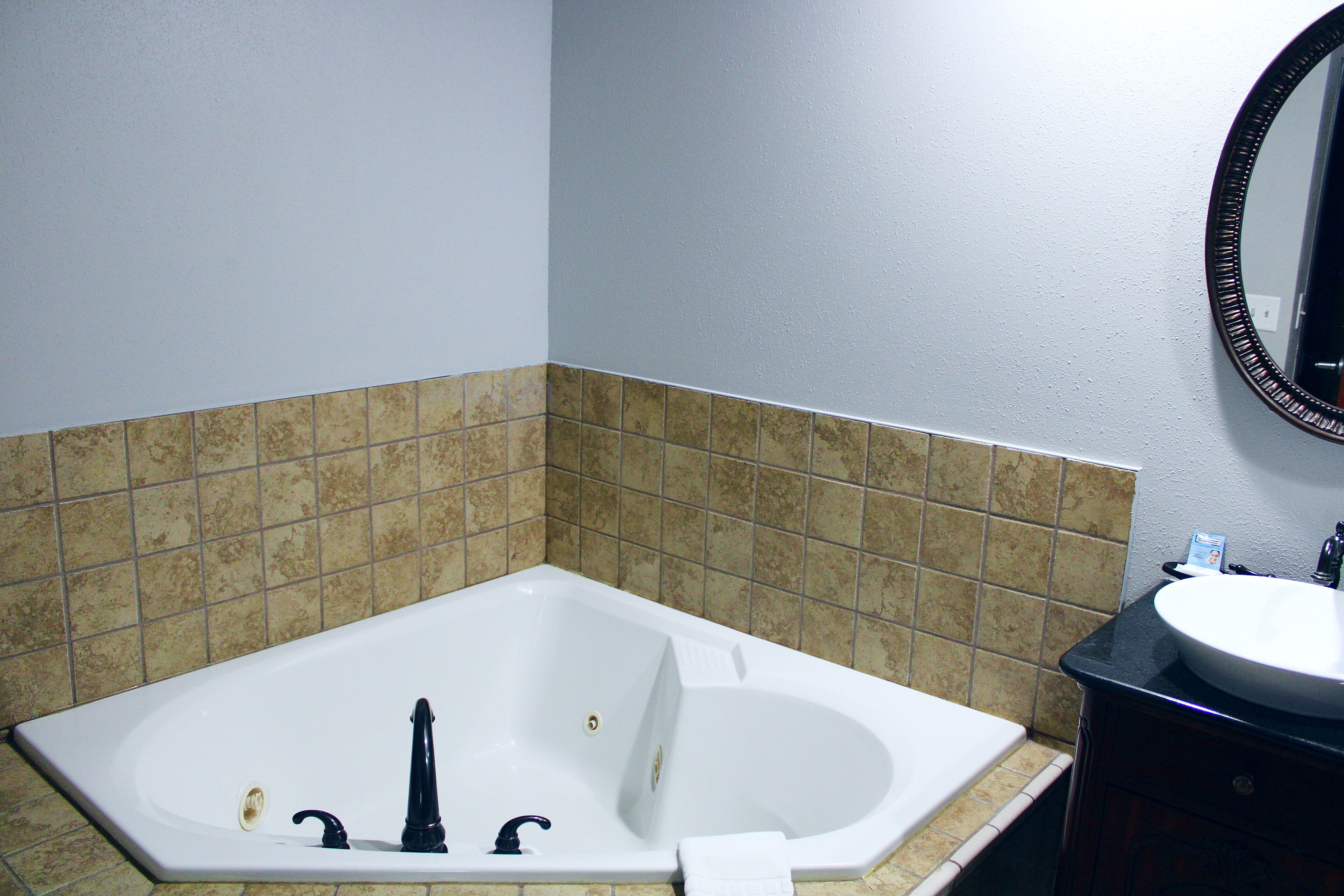 A bathroom with a bathtub, a sink, and a mirror.