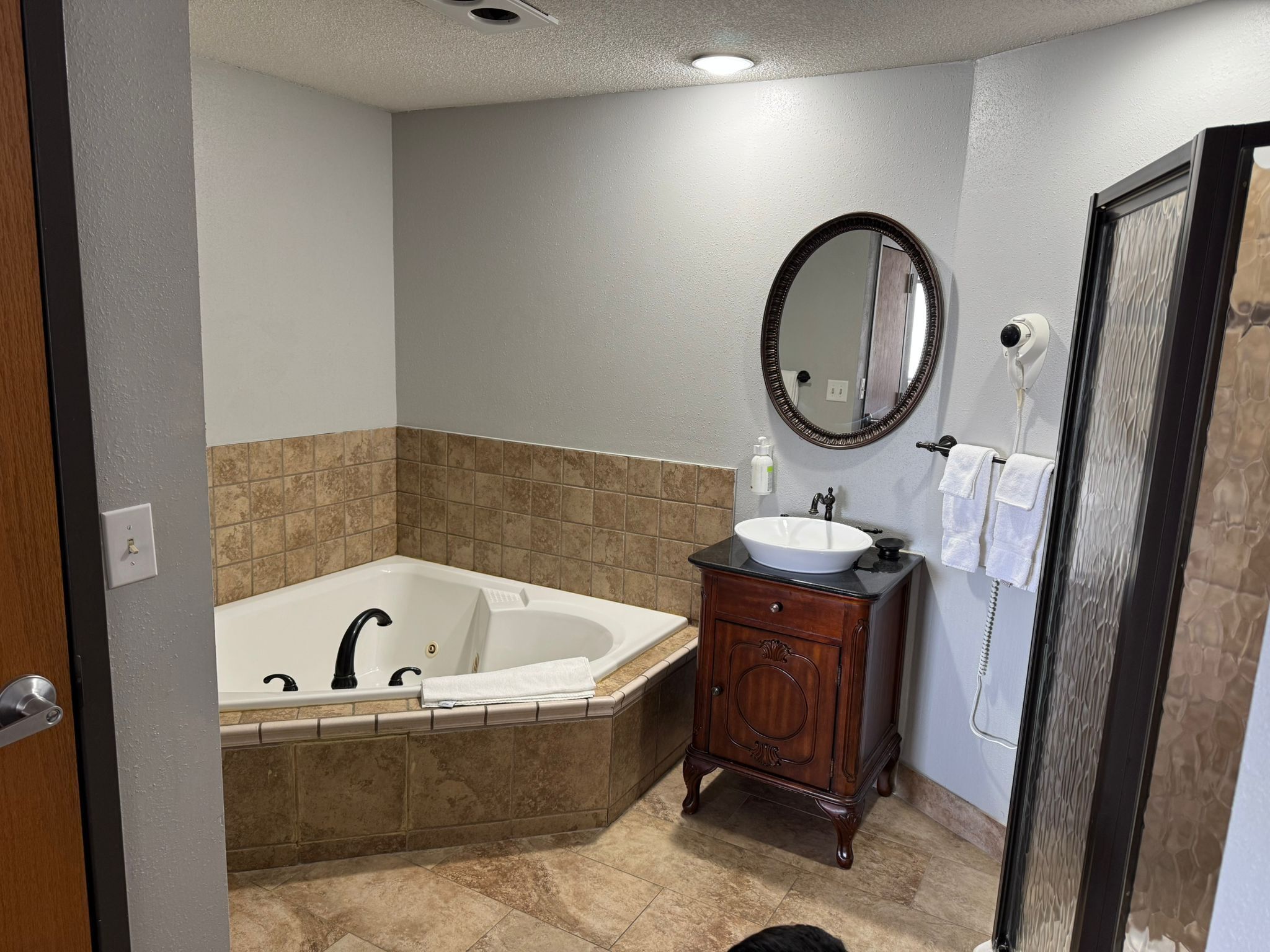 A bathroom with a bathtub, vanity, and a mirror.