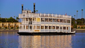 Un grand bateau fluvial à plusieurs ponts, à la coque blanche et doté de nombreux balcons répartis sur différents niveaux.