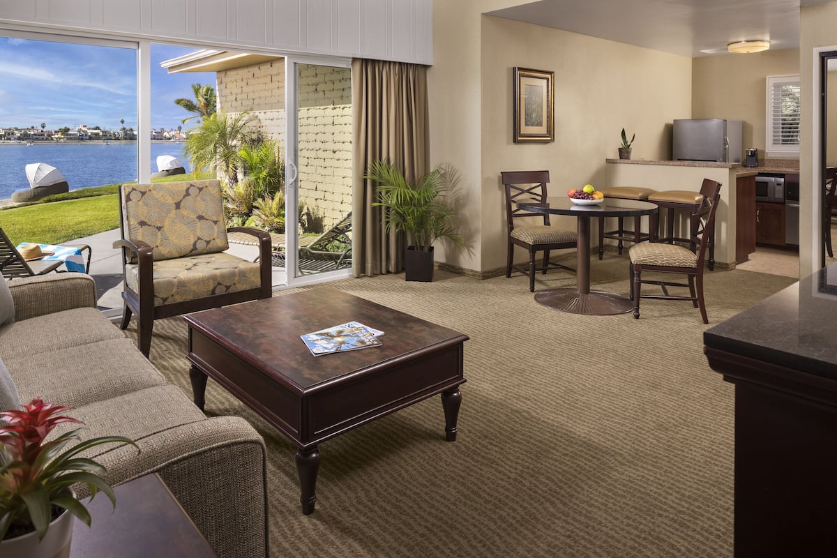 Une chambre d’hôtel avec balcon, un coin repas et une cuisine.