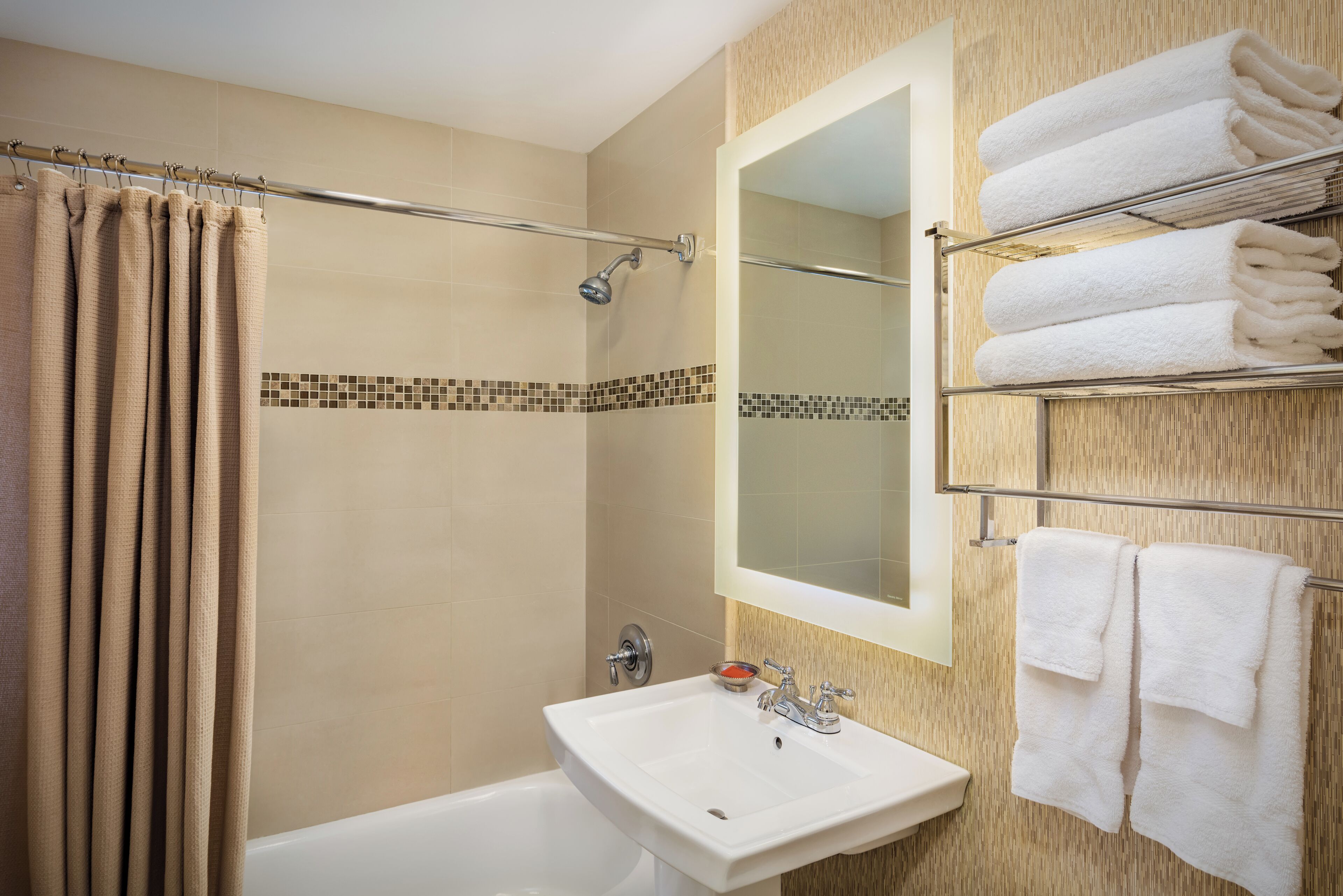 Une salle de bain avec une douche, un lavabo et un porte-serviettes.