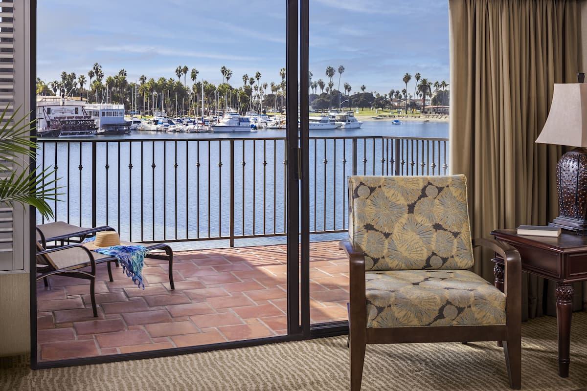 Un balcon avec une chaise, une table et une lampe.
