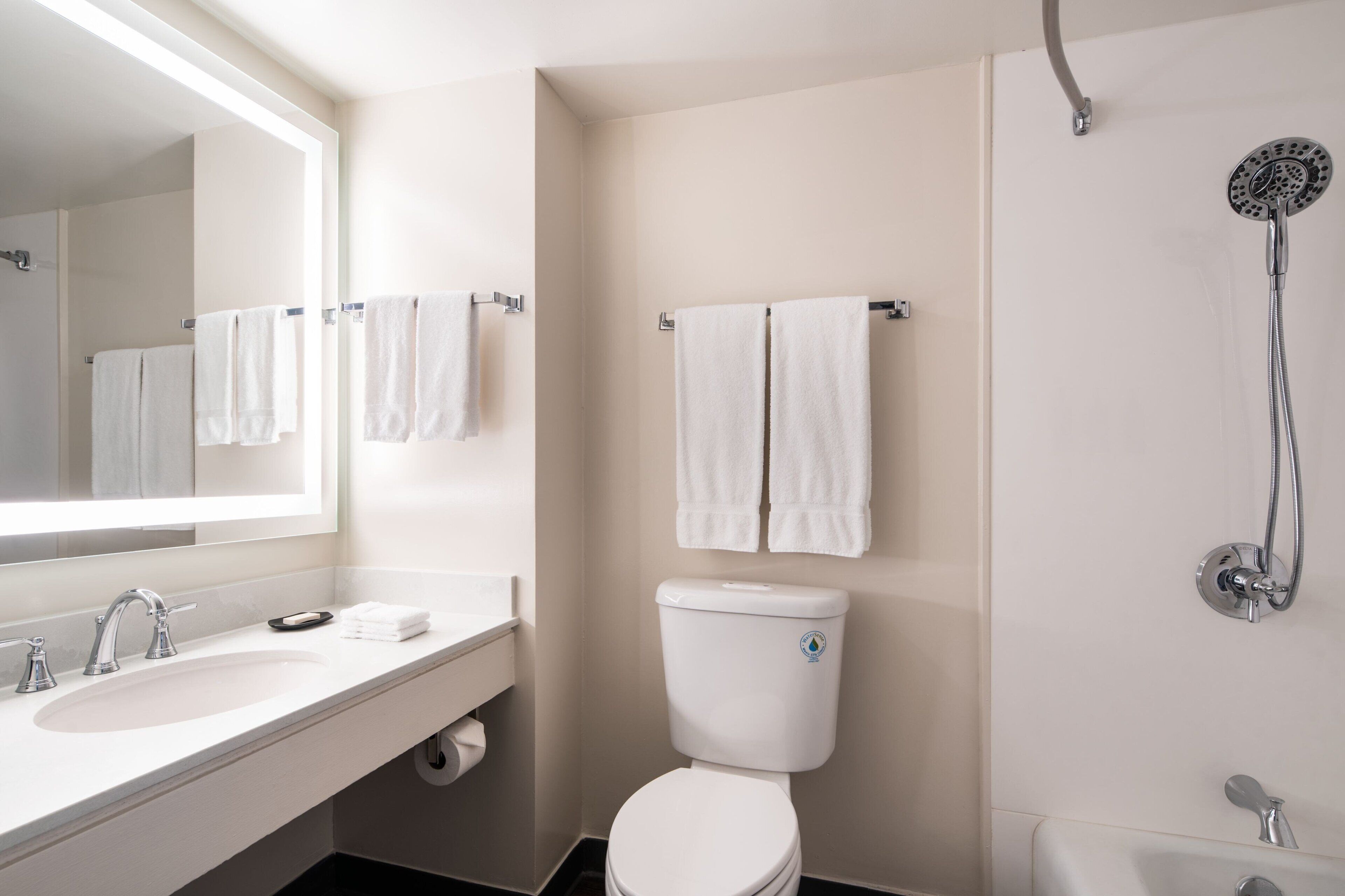 A modern bathroom with a white sink, toilet, and shower.