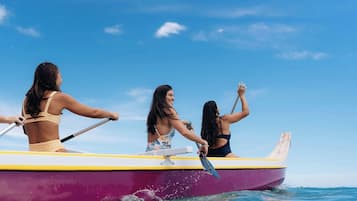 Tres personas remando en un bote pequeño sobre el agua.