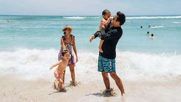 A beach scene with people playing in the water.