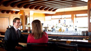 A bar area with wooden ceiling, bar counter, and seating. - Hotel Captain Cook (Anchorage)