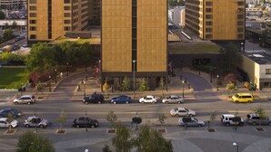 A modern building complex with multiple high-rise structures, a parking area, and a clear sky. - Hotel Captain Cook (Anchorage)