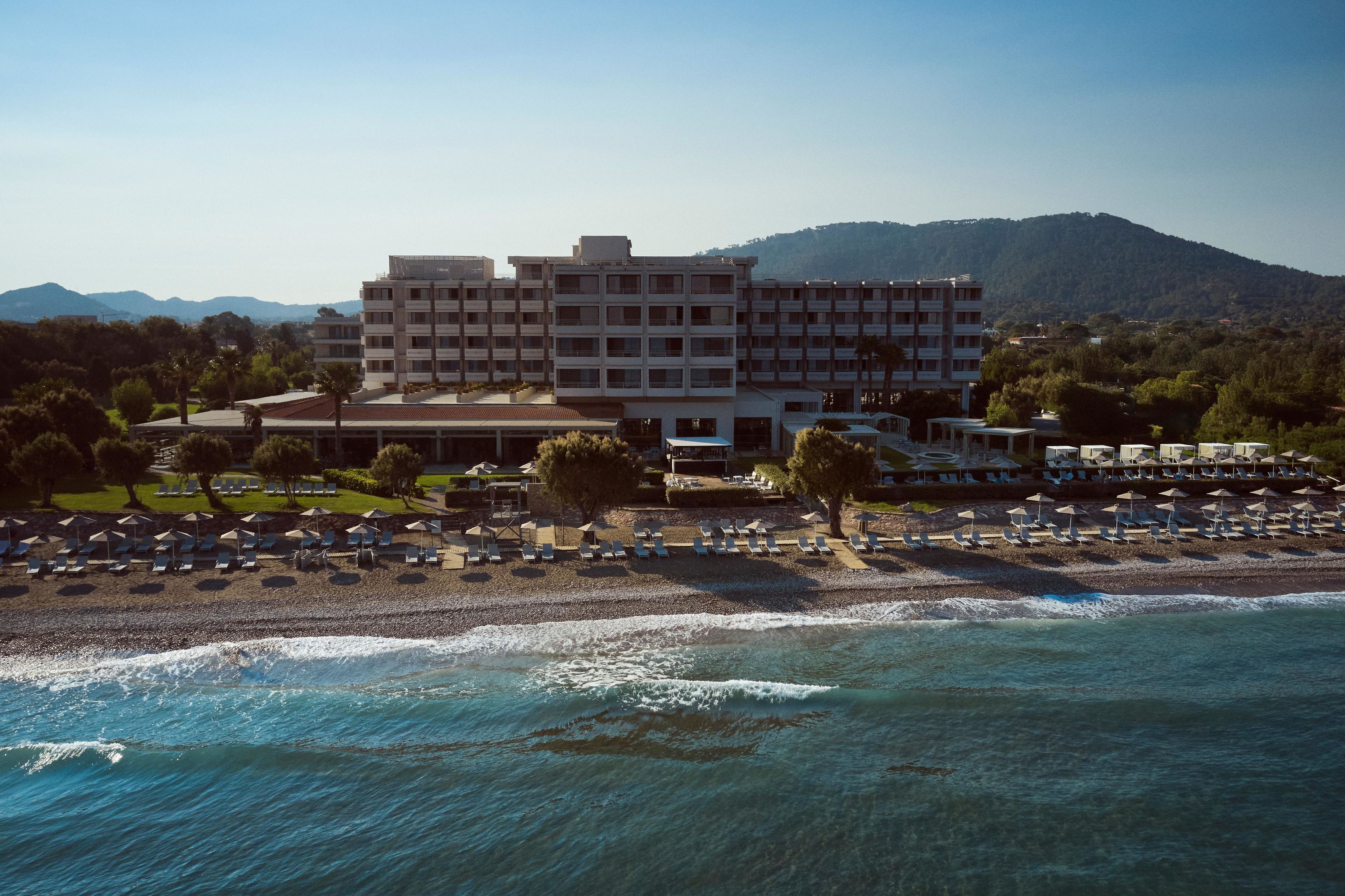 A hotel with multiple floors, a beachside location, and a view of the sea.