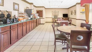 A breakfast area with a counter, waffle maker, coffee machine, and seating. - Days Inn by Wyndham Princeton (Princeton)