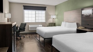 A hotel room with two beds, a desk, a chair, a lamp, and a window. - Baymont by Wyndham Santa Fe (Santa Fe)