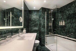 Ein modernes Badezimmer mit großem Spiegel, Waschbecken in Weiß, Toilette und einer Duschkabine.