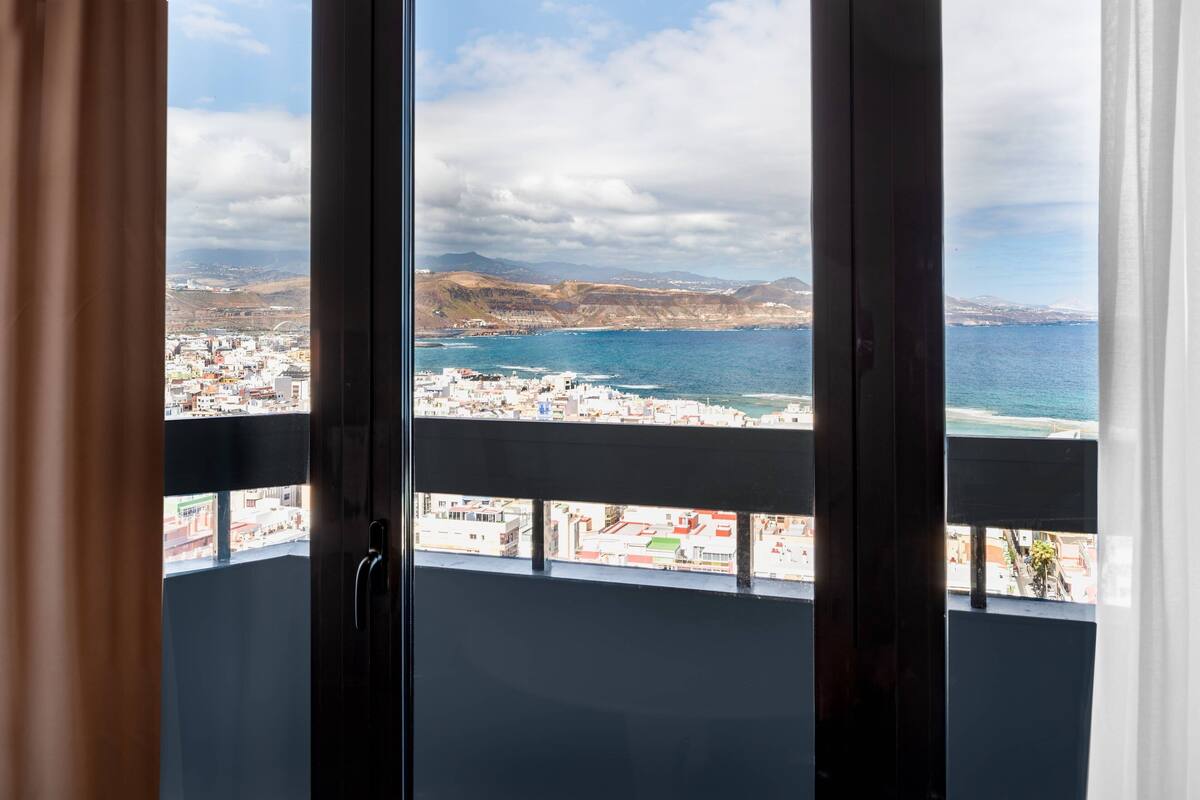 Un balcón con vista a un pueblo costero y al mar.