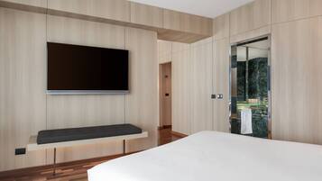 Un dormitorio moderno con una cama grande, un televisor montado y un panel de pared de madera.