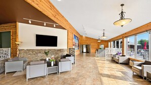 A spacious lobby with a modern design, featuring a large flat-screen TV, comfortable seating areas, and large windows offering views of the outdoors. - Best Western Plus Nor'wester Hotel & Conference Centre (Thunder Bay)
