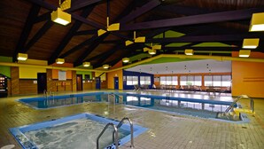 An indoor swimming pool with multiple lanes, a hot tub, and a lounge area with chairs and tables. - Best Western Plus Nor'wester Hotel & Conference Centre (Thunder Bay)