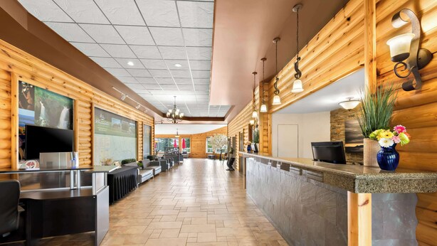 A hotel lobby with wooden paneling, a reception desk, seating area, and a large window with a view. - Best Western Plus Nor'wester Hotel & Conference Centre (Thunder Bay)