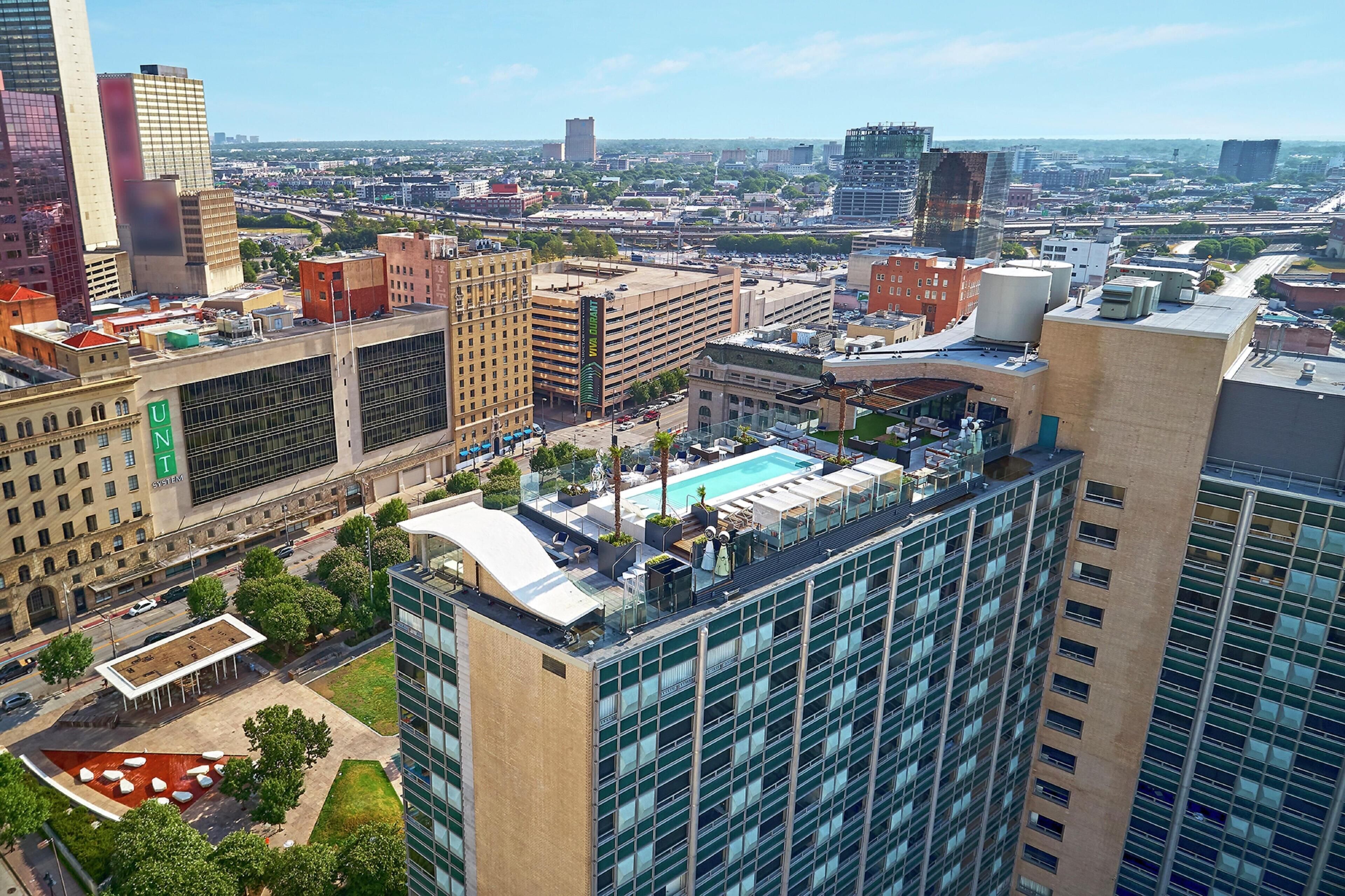 A high-rise building with a rooftop pool, a large glass facade, and a visible 'UN System' sign.