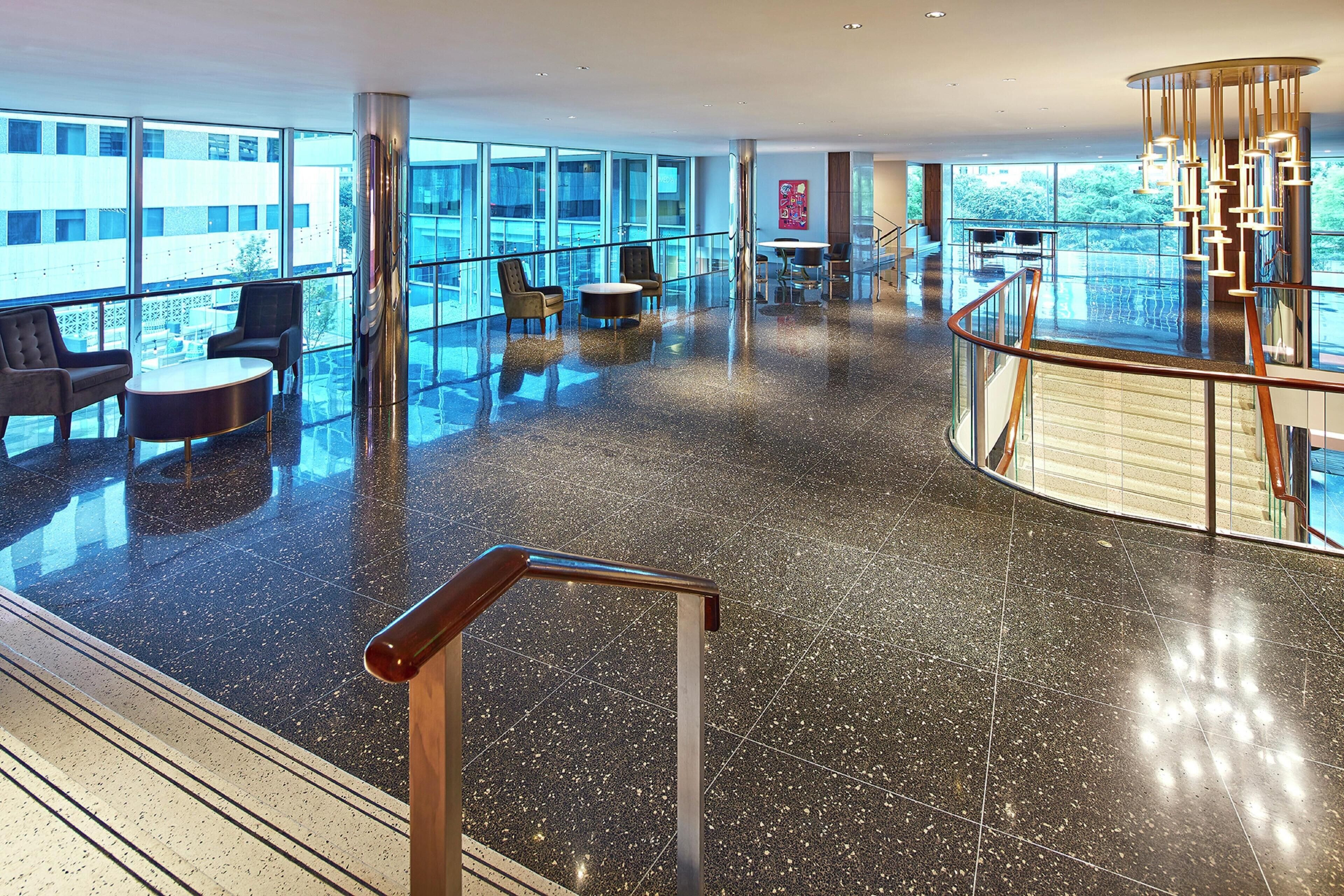 A spacious lobby with a glass floor, modern furniture, and a view of the city.