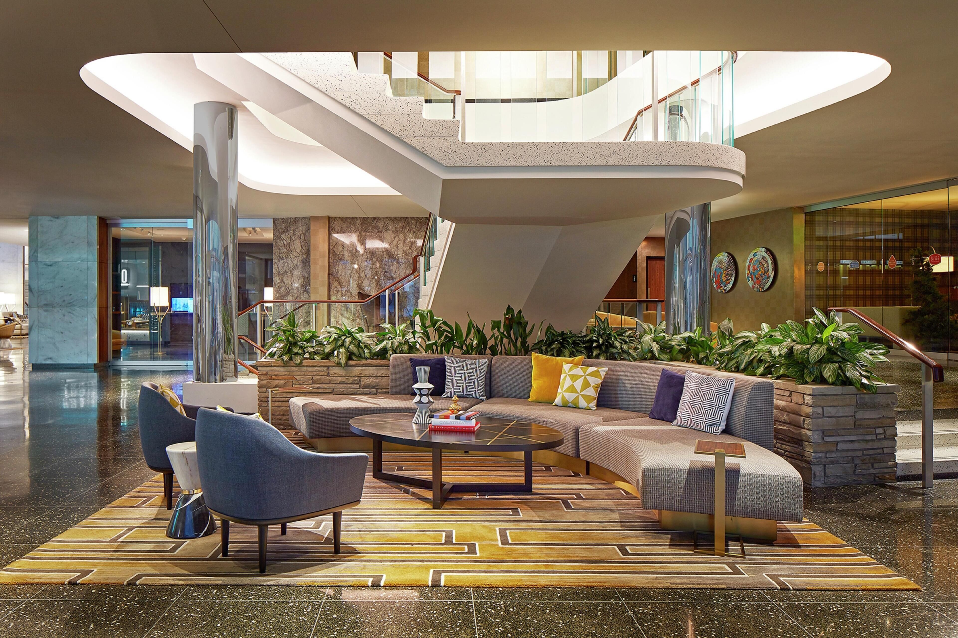 A spacious lobby with a modern staircase, seating area, and a view of the lobby area.