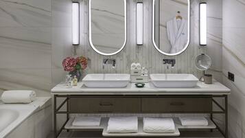 A modern bathroom with two sinks, a large mirror, and a towel rack.