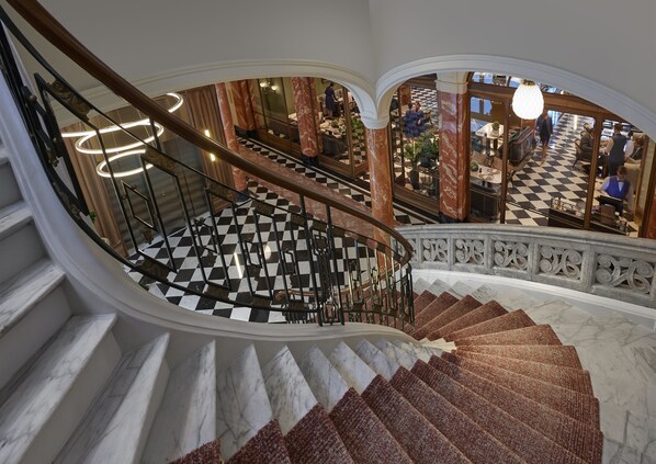 A grand staircase with a checkered floor, marble steps, and ornate railings. - Mandarin Oriental Palace, Luzern (Lucerne)