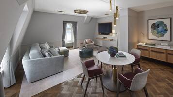 Ein modernes Wohnzimmer mit einem grauen Sofa, einem runden Esstisch und roten Stühlen.