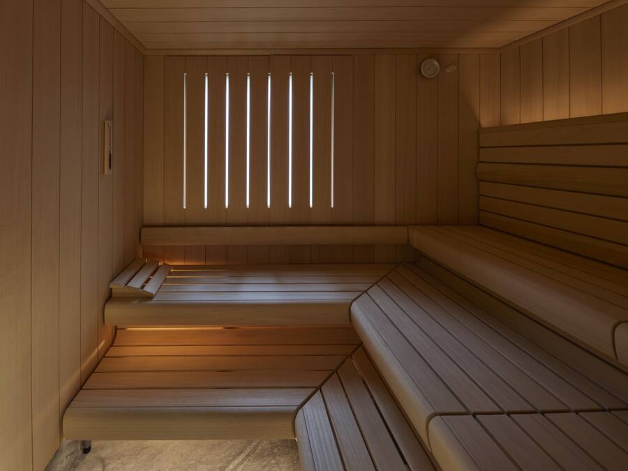 Een sauna met houten banken en een raamwerk van latten.