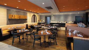 Un restaurant avec des banquettes et des tables, un comptoir avec un espace dédié au café, et un mur sur lequel est inscrit le mot « Fireside ».