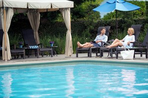 A poolside area with lounge chairs, a covered seating area, and a clear view of the pool. - Crowne Plaza Costa Mesa Orange County by IHG (Costa Mesa)