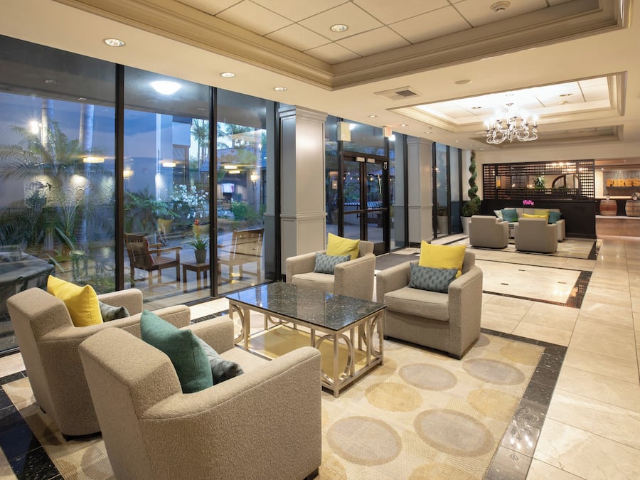 A spacious lobby with a seating area, large windows, and a reception desk.