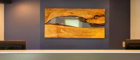 A reception area with a modern design, featuring a wooden wall art piece and a patterned floor.