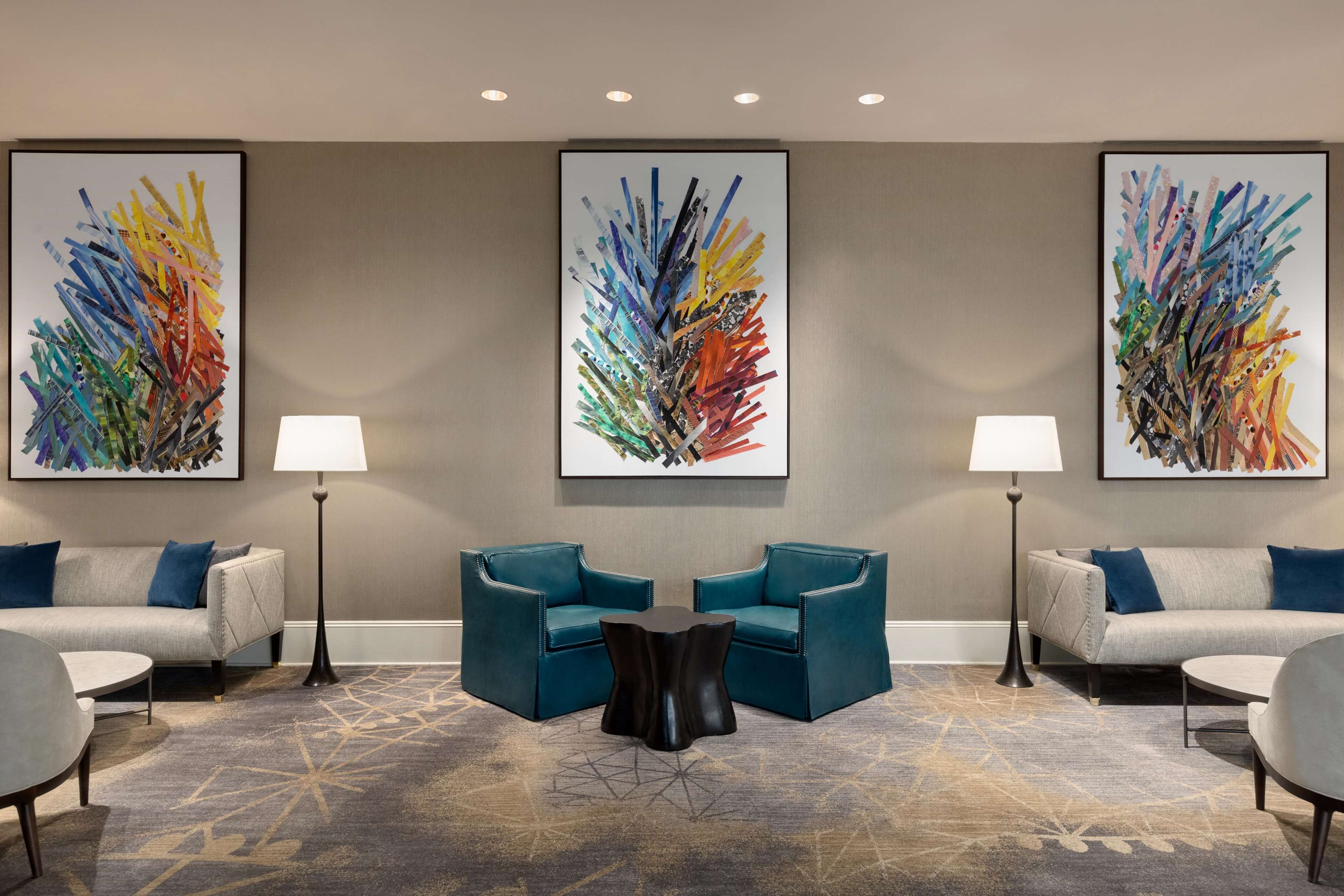 A modern hotel lobby with two sofas, a coffee table, and two floor lamps.