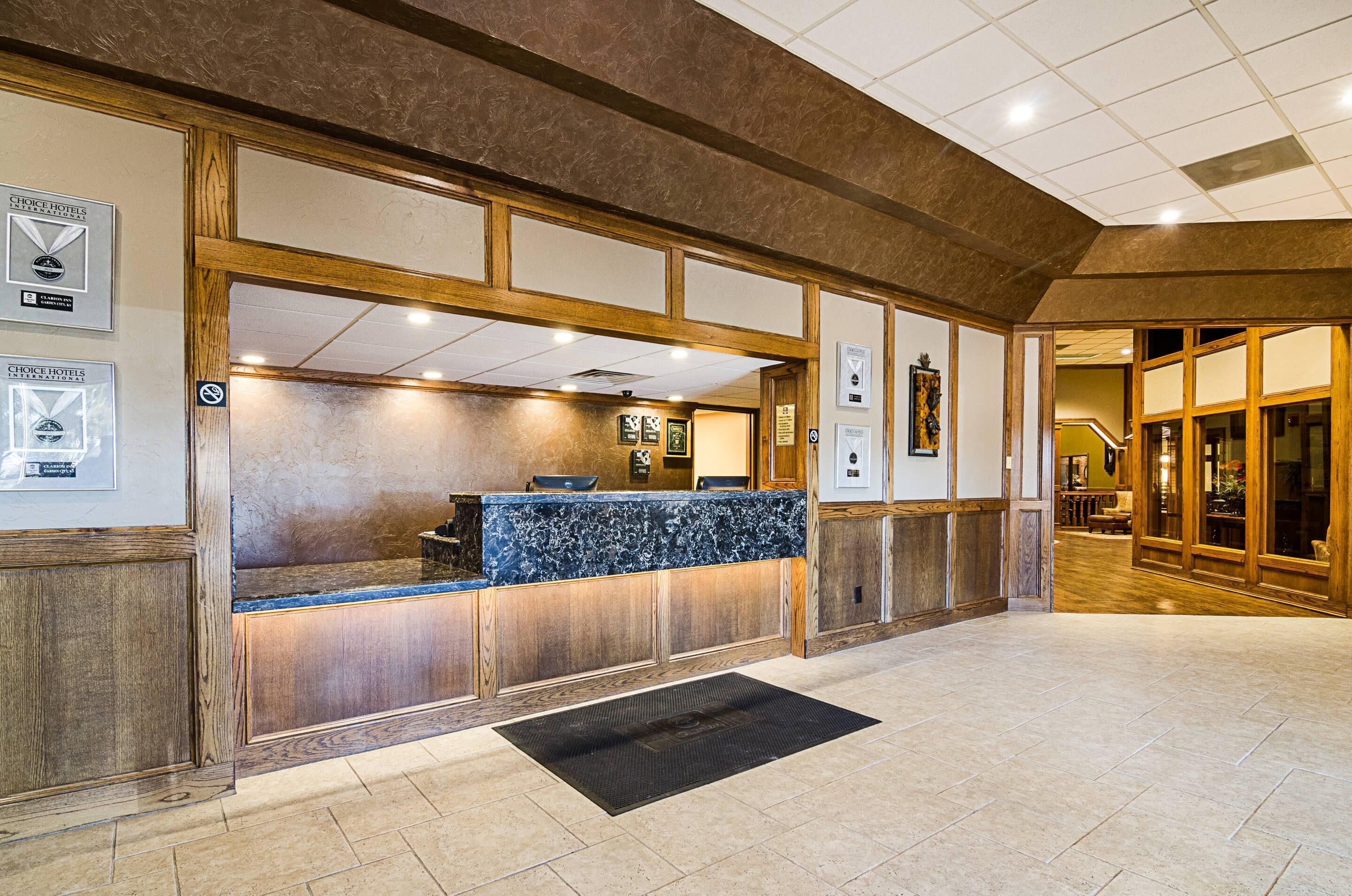 A reception area with a marble counter, wooden paneling, and framed awards on the walls.