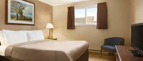 A hotel room with a bed, a chair, a desk with a television, a window with curtains, and a painting on the wall.