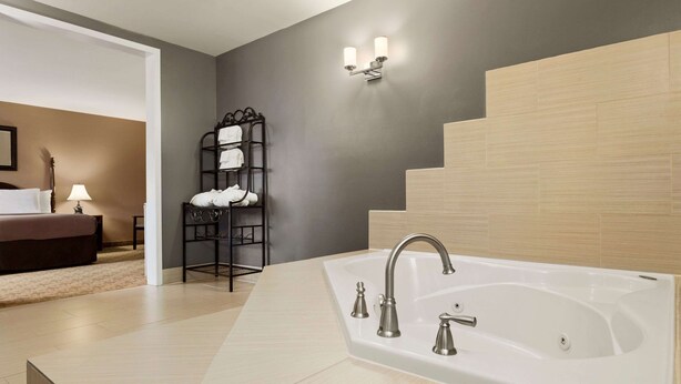 Un baño moderno con una bañera grande, un perchero y una escalera.