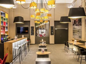 A bar area with multiple seating options, a television, and a menu board. - ibis Lyon Centre Perrache (Lyon)