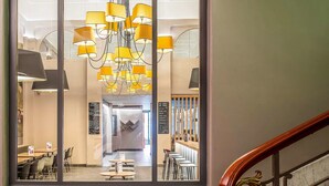 A hotel lobby with a modern chandelier, a reception desk, and a staircase with a red carpet. - ibis Lyon Centre Perrache (Lyon)