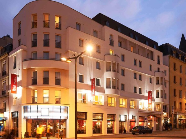 A multi-story hotel with balconies, a ground-level restaurant, and a car parked in front. - ibis Nancy Centre Gare et Congres (Nancy)