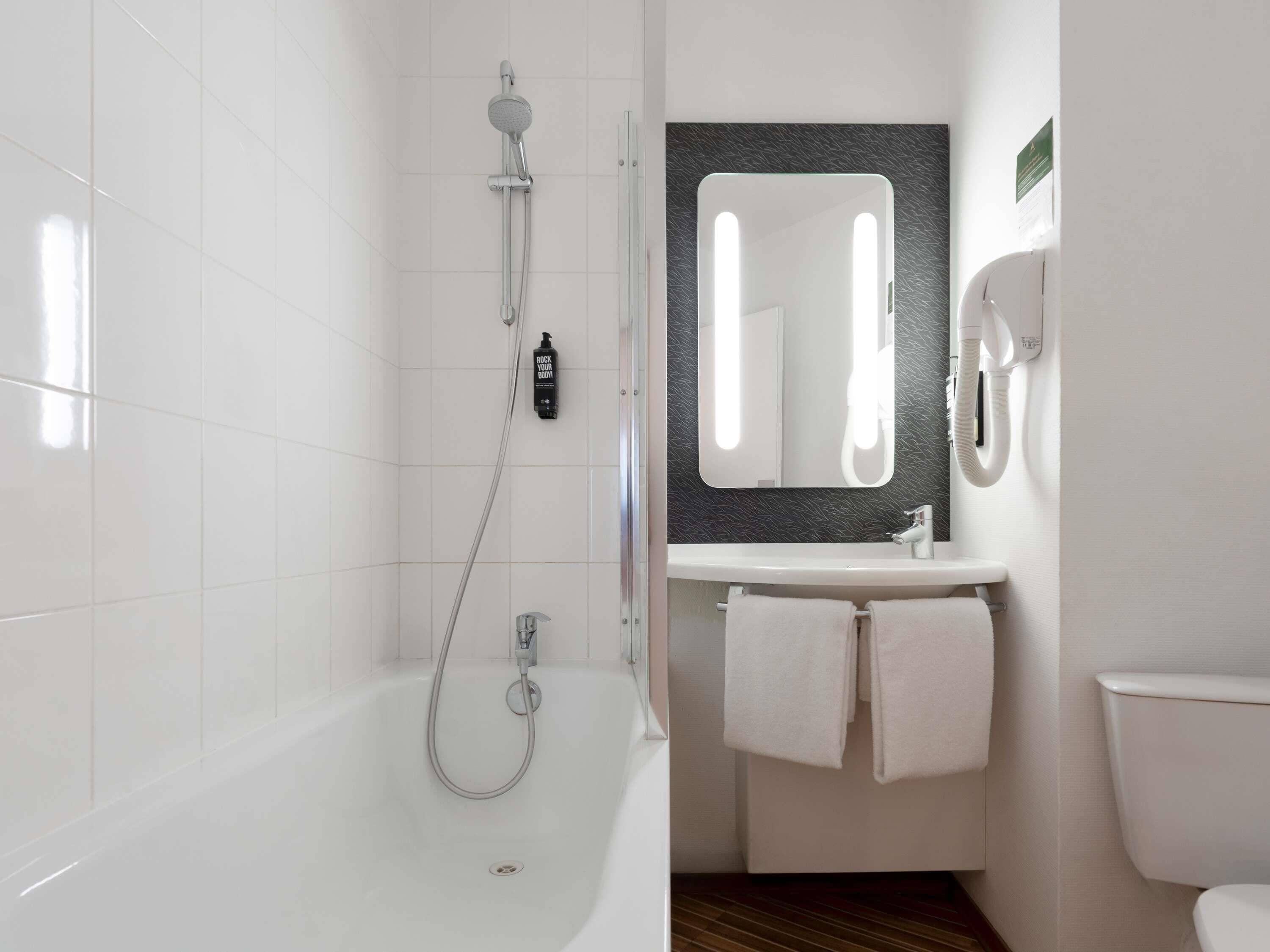 Ein modernes Badezimmer mit Badewanne, Waschbecken und Toilette.
