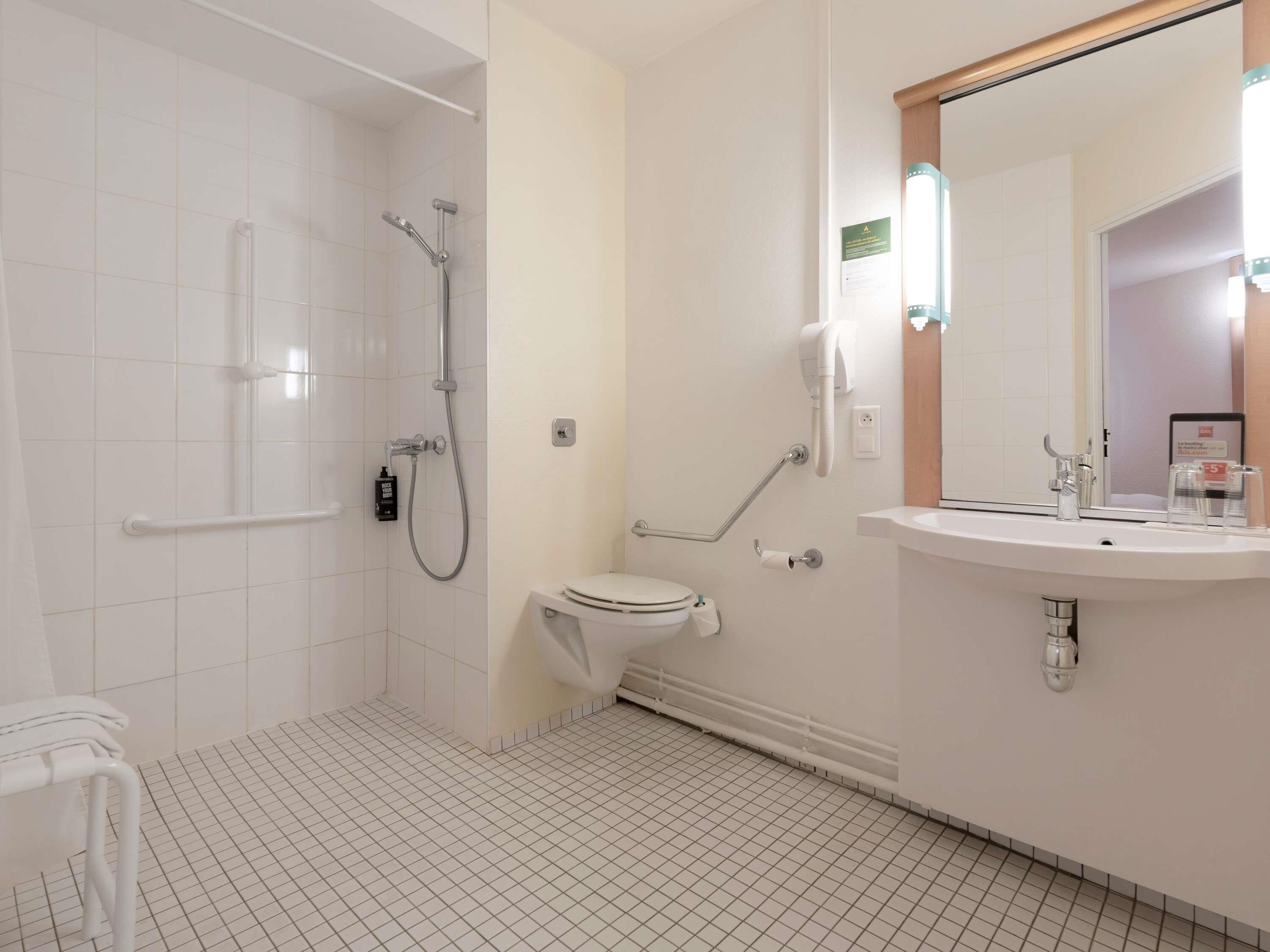 A modern bathroom with a shower, toilet, and sink.