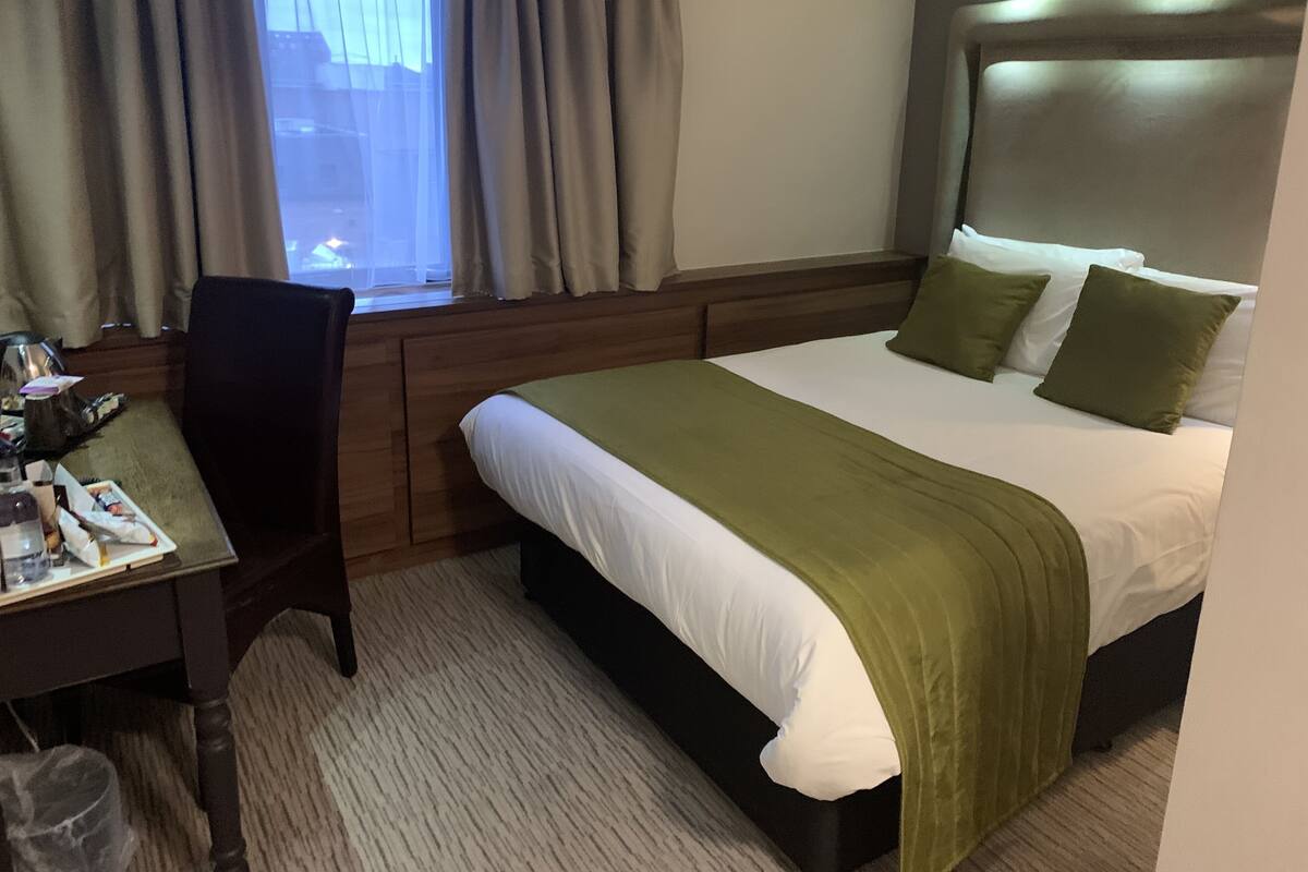 Ein Hotelzimmer mit einem Bett, einem Schreibtisch und einem Stuhl.